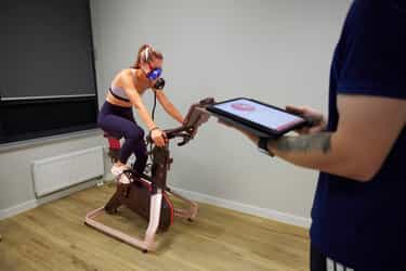 Sportwissenschaftler bereitet die Messung am Fahrradergometer vor