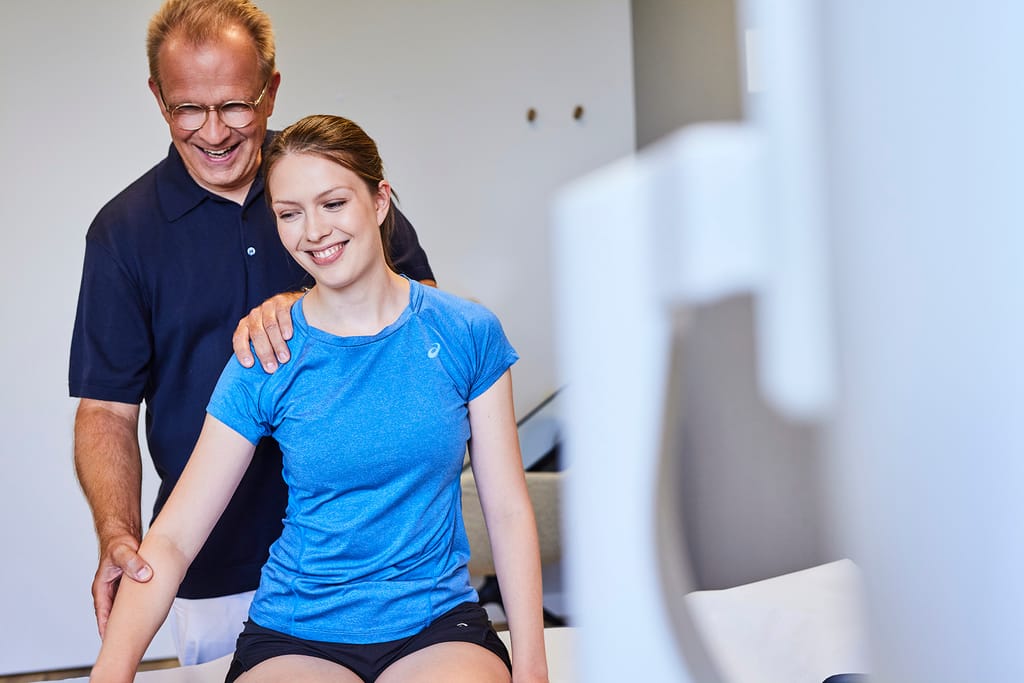 Arzt-Patienten-Gespräch auf der Behandlungsliege