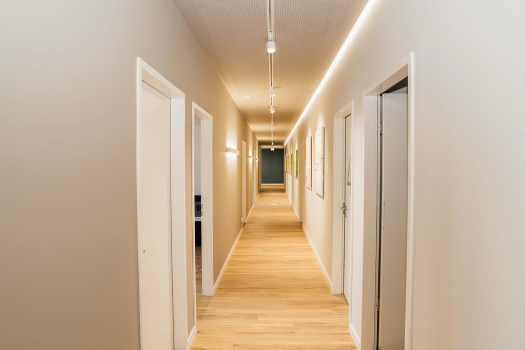 Praxisflur mit warmem Licht und Kunstwerken