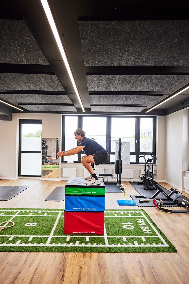 Sportler springt auf einen Sprungblock auf der Trainingsfläche